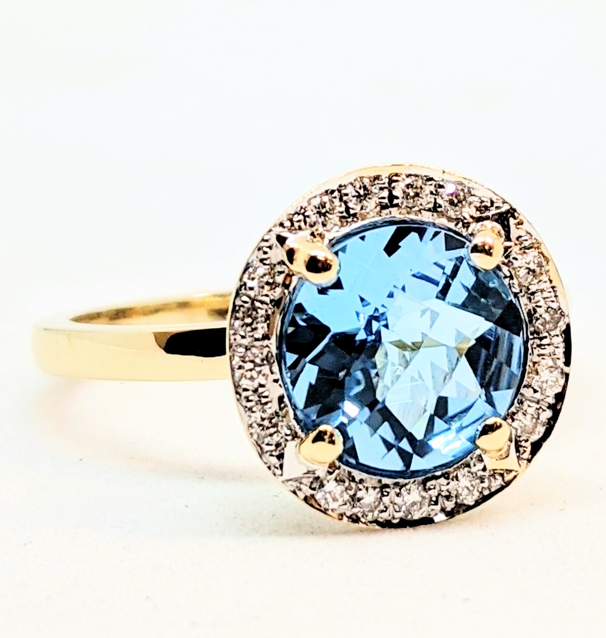 Bague or 14K, 16 diamants pour 0.1 carat total et 1 topaz bleu 8mm